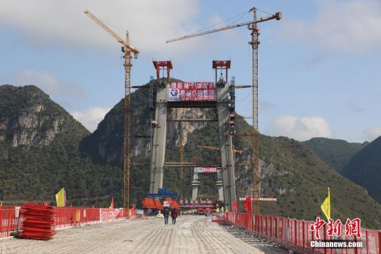 11月22日，正在建設中的峰林特大橋。當日，隨著1470噸裝配化預制中橫梁提升到位，貴州省黔西南布依族苗族自治州興義環(huán)城高速公路峰林特大橋4號主塔中橫梁成功吊裝，由此刷新了山區(qū)峽谷橋梁預制吊裝混凝土構件重量世界記錄。峰林特大橋是屬全線控制性工程。大橋跨越馬嶺河峽谷，全長1163米，主跨采用550米懸索橋，橋面離谷底364.2米，是中國山區(qū)第一座大跨徑鋼混疊合梁懸索橋。中新社記者 瞿宏倫 攝