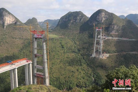 11月22日，正在建設中的峰林特大橋。當日，隨著1470噸裝配化預制中橫梁提升到位，貴州省黔西南布依族苗族自治州興義環(huán)城高速公路峰林特大橋4號主塔中橫梁成功吊裝，由此刷新了山區(qū)峽谷橋梁預制吊裝混凝土構件重量世界記錄。峰林特大橋是屬全線控制性工程。大橋跨越馬嶺河峽谷，全長1163米，主跨采用550米懸索橋，橋面離谷底364.2米，是中國山區(qū)第一座大跨徑鋼混疊合梁懸索橋。中新社記者 瞿宏倫 攝